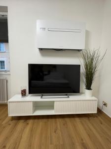 a white entertainment center with a tv on a wall at Bethel House in Gardone Riviera
