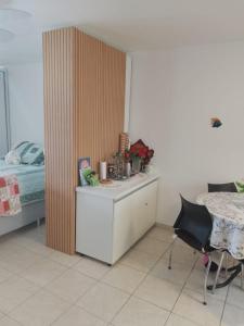 a bedroom with a bed and a desk and a table at Flat super top in Guaratuba