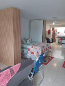 a bedroom with a bed and a chair in it at Flat super top in Guaratuba