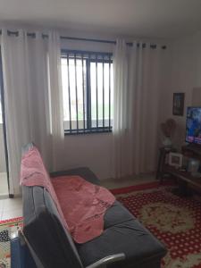 a living room with a couch and a window at Flat super top in Guaratuba +9 photos
