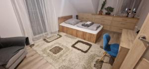 a small room with a rug and a blue chair at Cudowny zakątek BIS in Bukwica