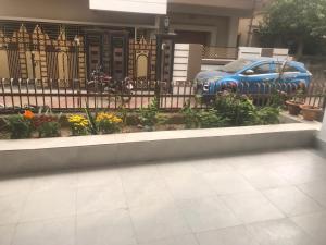 a car parked in front of a fence with flowers at Bhoomi mansion Apartment 23 in Bhubaneshwar
