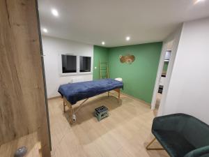 a room with a bed and a green wall at Mon Nid'éal de Bien-être in Saint-Forgeux