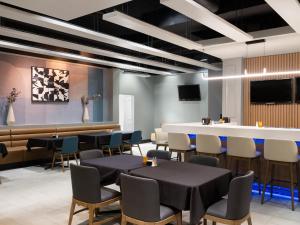 a restaurant with tables and chairs and a bar at Holiday Inn Portsmouth Downtown by IHG in Portsmouth +31 photos