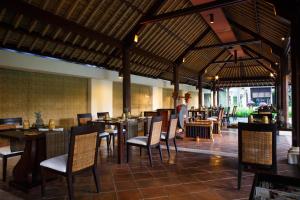 a restaurant with tables and chairs in a room at Kayumanis Sanur Private Villa and Spa in Sanur