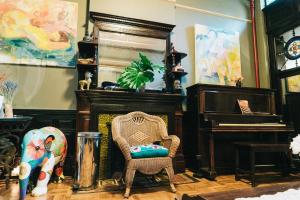 a living room with a chair and a piano at Northern Lights Mansion in New York