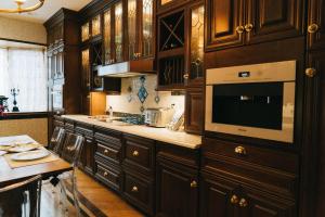 a kitchen with wooden cabinets and a table and a microwave at Northern Lights Mansion in New York
