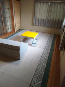 a room with a yellow table and a couch at Yoshinogawa - House - Vacation STAY 98531v in Yoshinogawa