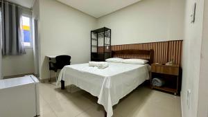 a bedroom with a bed with a white blanket at Hotel Brisas in Bom Jesus da Lapa