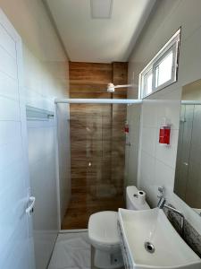 a bathroom with a shower and a toilet and a sink at Hotel Brisas in Bom Jesus da Lapa