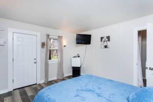 a bedroom with a blue bed and a tv on the wall at Saratoga Cabins in Malta
