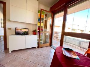a living room with a couch and a tv and some windows at Vacanze Romane LB&C in Rome