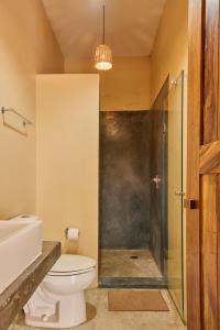 a bathroom with a toilet and a glass shower at Lya Beach House in Santa María Colotepec