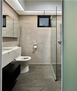 a bathroom with a toilet and a glass shower at Hotel Venture Grand in Mumbai