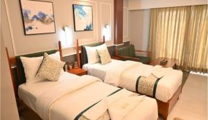 a hotel room with two beds and a couch at Hotel Venture Grand in Mumbai