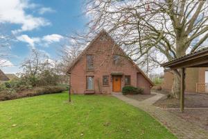 a brick house with a orange door in a yard at Haus Marieke in Lehe