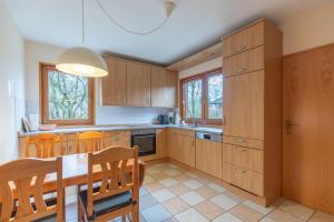 a kitchen with wooden cabinets and a table and chairs at Haus Marieke in Lehe