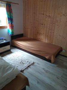 ein Schlafzimmer mit einem Bett und einem Holzboden in der Unterkunft Oleandria-,, Domek Poziomeczka" nr 33 -ogrzewany w okresie jesienno-zimowym in Biskupiec