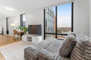 a bedroom with a bed and a large window at Furnished Luxury Apartment Next to Harvard Stadium in Boston