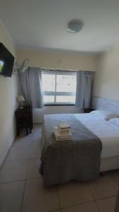 a bedroom with a bed with towels on it at Hotel Bertiami in Mar del Plata +12 photos