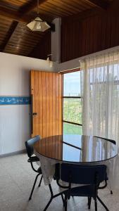 een eetkamer met een glazen tafel en 2 stoelen bij Mejía CampoMar in Mejia