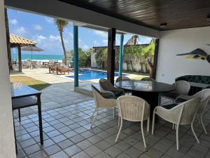 a patio with a table and chairs and a pool at Mar a Vista Charme by Concavus in Porto De Galinhas