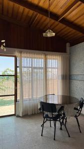 een eetkamer met een tafel en stoelen en een raam bij Mejía CampoMar in Mejia