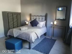 a bedroom with a large bed and a blue rug at Casablanca B&B in Beaufort West