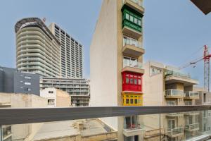 a view of buildings with red and yellow windows at Amazing Location in St Julian's, Paceville 2 Bedroom, with Balcony by Vaganza in St Julian's