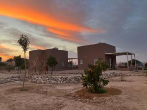 a building in the middle of a desert with a sunset at בריזה במדבר in Idan