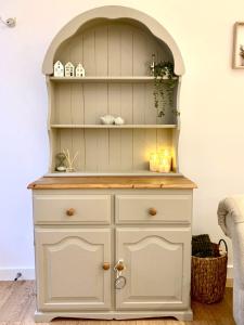 a white hutch with an arch above it at Quaint Cottage in Kirkwall in Kirkwall +10 photos
