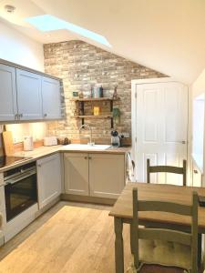 a kitchen with white cabinets and a wooden table at Quaint Cottage in Kirkwall in Kirkwall
