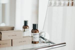 a bottle of essential oils sitting on a shelf in front of a mirror at Le Petit Hotel Notre Dame in Montreal