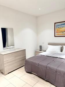 a bedroom with a bed and a flat screen tv at PALAZZO PROIETTI BILOCALE 5 in Biella +16 photos