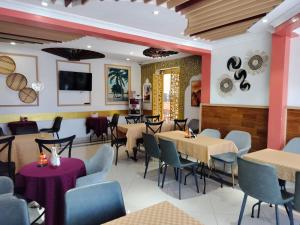 a restaurant with tables and chairs and a flat screen tv at Raha Hotel & Suites in Nairobi