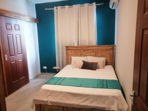 a bedroom with a bed with a blue wall at Mauritius Heights in Flic-en-Flac