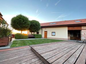 a yard with a wooden deck in front of a house at Apartmán Na Sluneční Valtice in Valtice