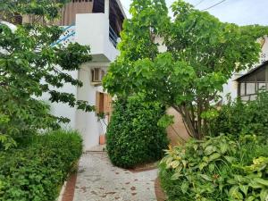a garden with trees and bushes in front of a building at Marie Jose in Saint-Louis