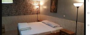a bedroom with a bed with two lamps and a brick wall at Marie Jose in Saint-Louis