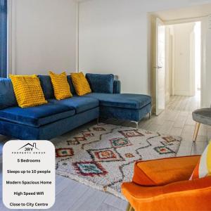 a living room with a blue couch and a rug at The Luxury Home Free Parking 10 Min Walk to Cardiff Town in Cardiff
