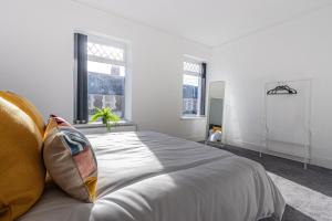 a white bedroom with a large bed with pillows at The Luxury Home Free Parking 10 Min Walk to Cardiff Town in Cardiff