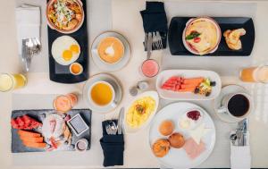 a table topped with plates of breakfast foods and drinks at Hotel Miraflores in Ambato