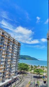 a large apartment building with a parking lot next to the ocean at Quadra da Praia, Vista Mar, Boqueirão Gonzaga in Santos