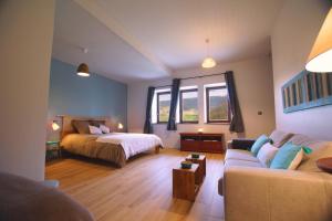 duży pokój z łóżkiem i kanapą w obiekcie Terres de la Grange w mieście Cuisiat
