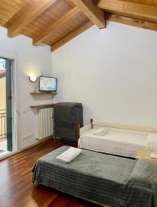 two beds in a room with a tv on the wall at Villa Maragno vicino Abano Terme in Padova