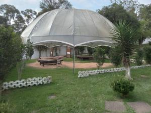 a large tent in a yard with a bench and a tree at Arena da serra festy in Itapecerica da Serra