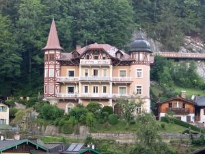 een huis met een torentje op een heuvel met huizen bij Villa Marktresidenz - Ihre Ferienwohnungen im Herzen von Berchtesgaden in Berchtesgaden