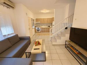 a living room with a couch and a table at Ageri II Beach Front Apartment in Hanioti