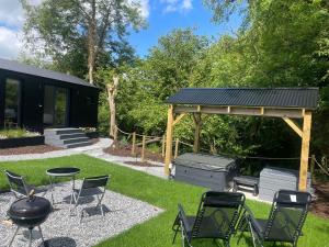 a gazebo with chairs and a grill in a yard at Riverside Retreat in Monaghan +21 photos