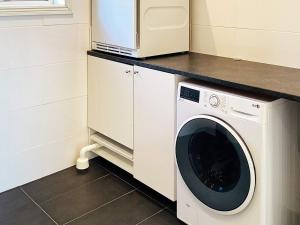 a kitchen with a washing machine and a microwave at 4 star holiday home in FAGERFJÄLL-By Traum in Åkervik